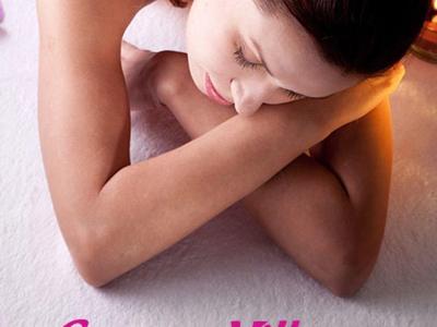 Frau liegt entspannt, Hot-Stone-Massage auf Rücken, sanftes Licht, Wellness-Atmosphäre.