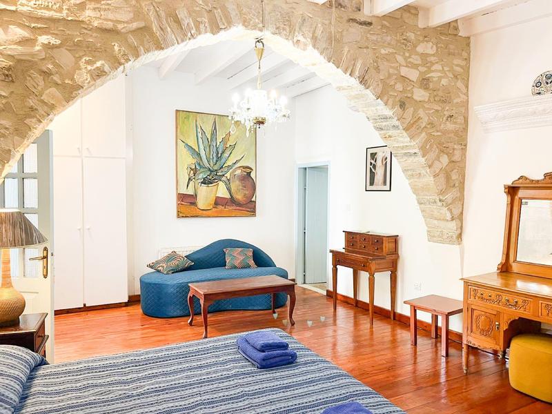 Gemütlicher Wohnbereich mit Steinbogen, blauer Couch und Holzmöbeln in einem Ferienhaus.