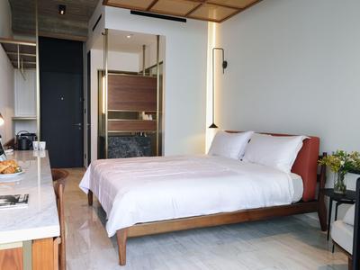 Przytulny pokój hotelowy z dużym łóżkiem, nowoczesnym designem i biurkiem.