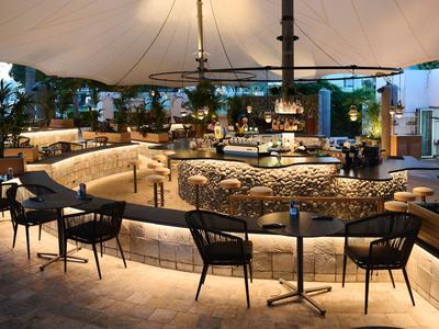 Moderní bar s pohodlnými židlemi a kreativním osvětlením v hotelu