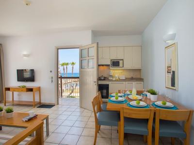 Modernes Hotelzimmer mit zwei Einzelbetten, Glaswand, Schreibtisch und hellen Farben.
