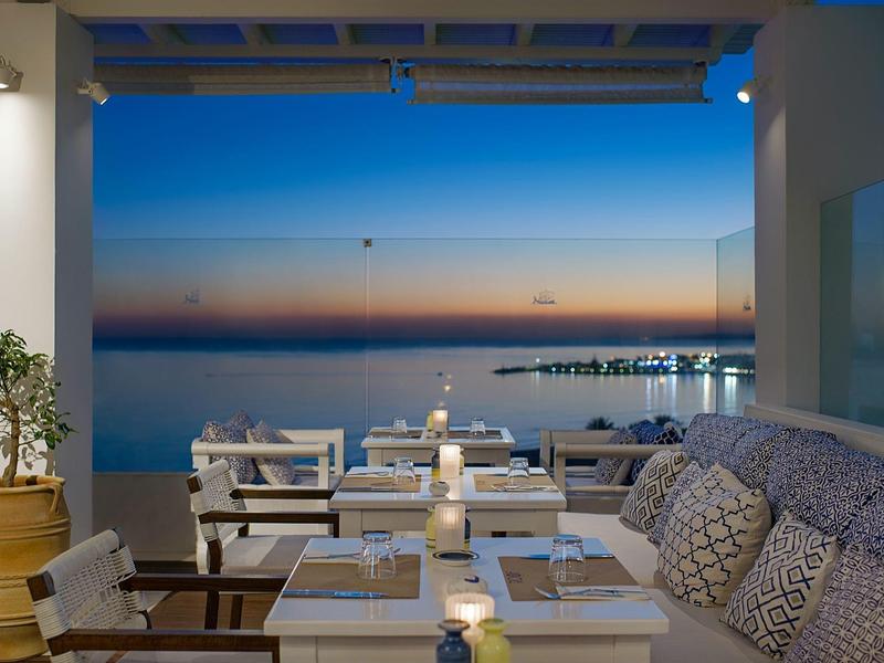 Terrasse mit Sitzgelegenheiten und Blick auf das Meer bei Sonnenuntergang
