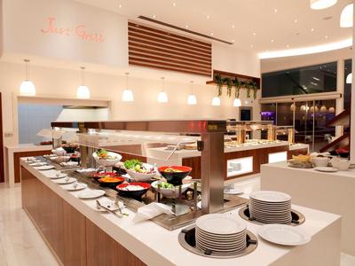 Buffetbereich mit modernen Holztheken, vielen Tellern, Schüsseln und warmen Speisen in heller, offener Umgebung.