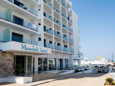 Moderner Hotelkomplex mit Balkonen und klar blauem Himmel an der Küste.