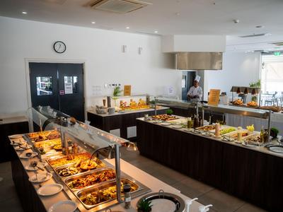 Buffetbereich in einem modernen Hotel mit vielfältigen Speisen präsentiert auf langen Tischen.