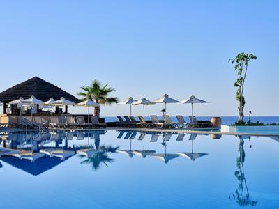Area piscina con lettini e ombrelloni contro cielo azzurro e vista mare
