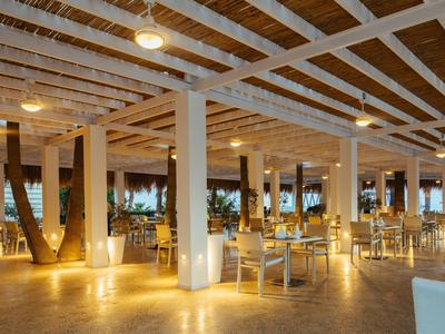 Amplio comedor moderno con techos de madera e iluminación elegante en un hotel.