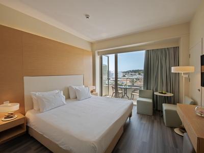 Nowoczesny pokój hotelowy z dużym łóżkiem i balkonem z widokiem na morze