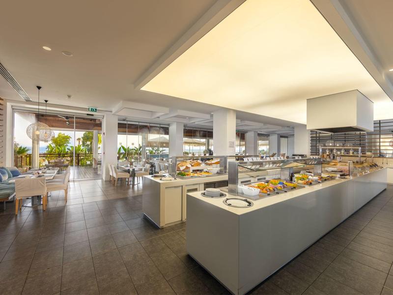 Helles modernes Buffet mit großen Fenstern und Sitzbereichen in einem Restaurant.