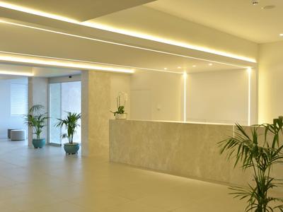 Moderne en lichte hotelreceptie met planten en minimalistisch ontwerp.