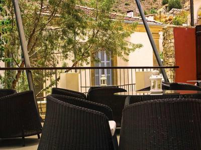 Blick auf einen Außenbereich mit schwarzen Stühlen und Tischen auf einer Terrasse.