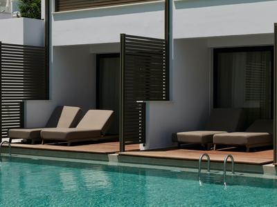 Nowoczesny basen hotelowy z leżakami i osłonami prywatności przy pokojach