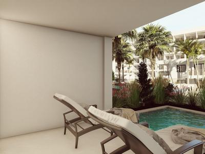 Nowoczesny taras z dwoma leżakami i małym basenem przed palmami i budynkiem hotelu.