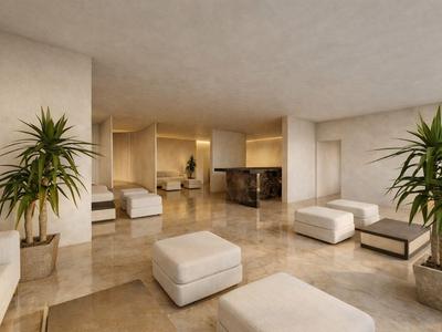 Nowoczesna strefa wypoczynkowa hotelu z wygodnymi białymi siedziskami i dużymi doniczkami roślin.