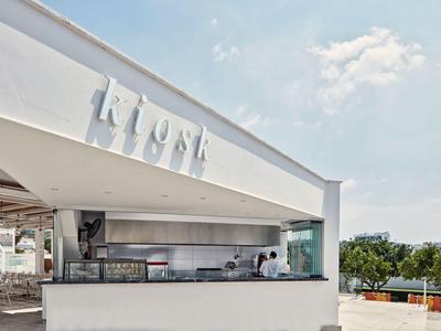 Nowoczesna przestrzeń na zewnątrz z barem i widokiem na morze w słoneczny dzień.