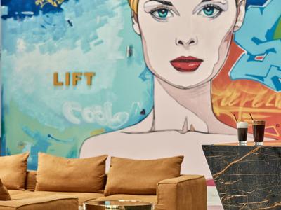 Moderne Hotelbar mit Kunstwand und bequemen braunen Sofas.