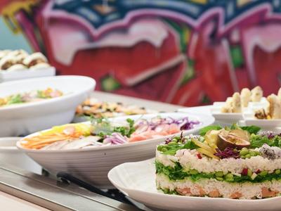 Vielfältige Salate in Schüsseln präsentiert mit farbenfrohem Hintergrund.