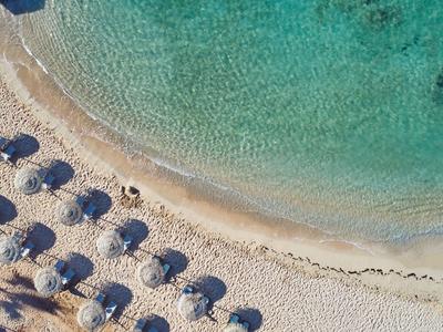 Vue aérienne d'une plage de sable avec parasols et eau turquoise claire