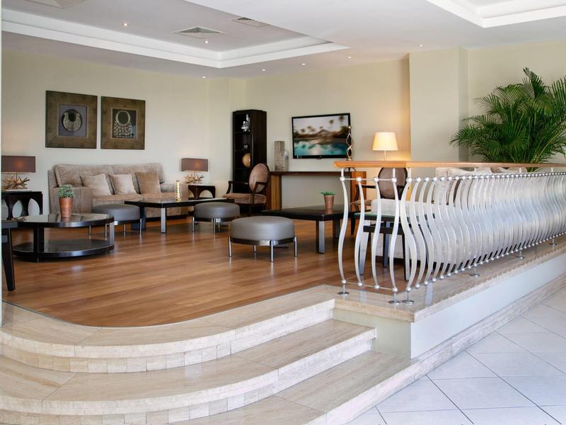 Helle, moderne Wohnzimmerecke mit Holzfußboden, gemütlichen Sofas und dekorativem Geländer.