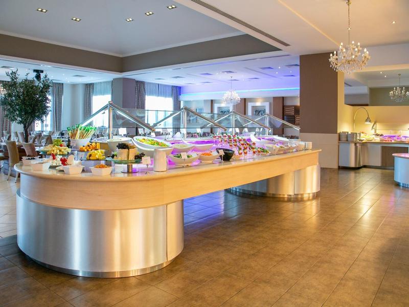 Großer Buffetbereich mit beleuchtetem Buffet-Tresen und vielfältigen Speisen in hellem Raum.