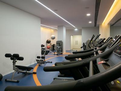Moderner Fitnessraum mit Laufbändern und verschiedenen Trainingsgeräten in einem Hotel.