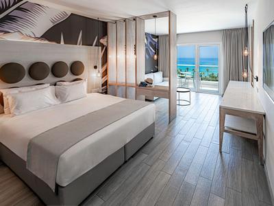 Modern eingerichtetes Hotelzimmer mit Doppelbett, Balkon und Meeresblick.