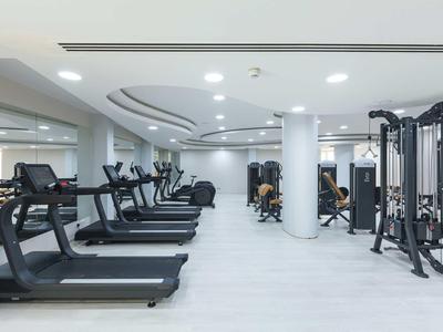 Moderner Fitnessraum mit Laufbändern und Kraftgeräten in hellen, offenen Räumen.