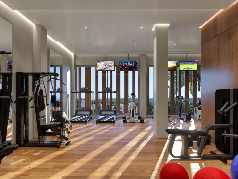 Modern gym with treadmills, weights, and fitness balls in a bright room.