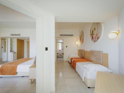 Chambre d'hôtel lumineuse avec deux lits et décoration moderne.