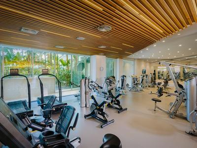 Salle de sport moderne avec divers équipements et fenêtres panoramiques.