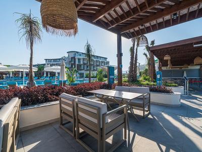 Buiten lounge met moderne zitplaatsen en tropische planten onder houten dak.