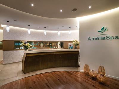 Moderne spa-receptie met houten vloer en zachte verlichting.