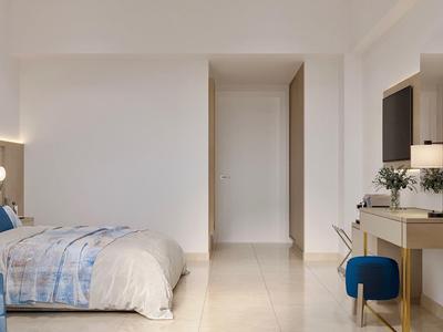 Lichte hotelkamer met bed, bureau en stoel in neutrale kleuren.