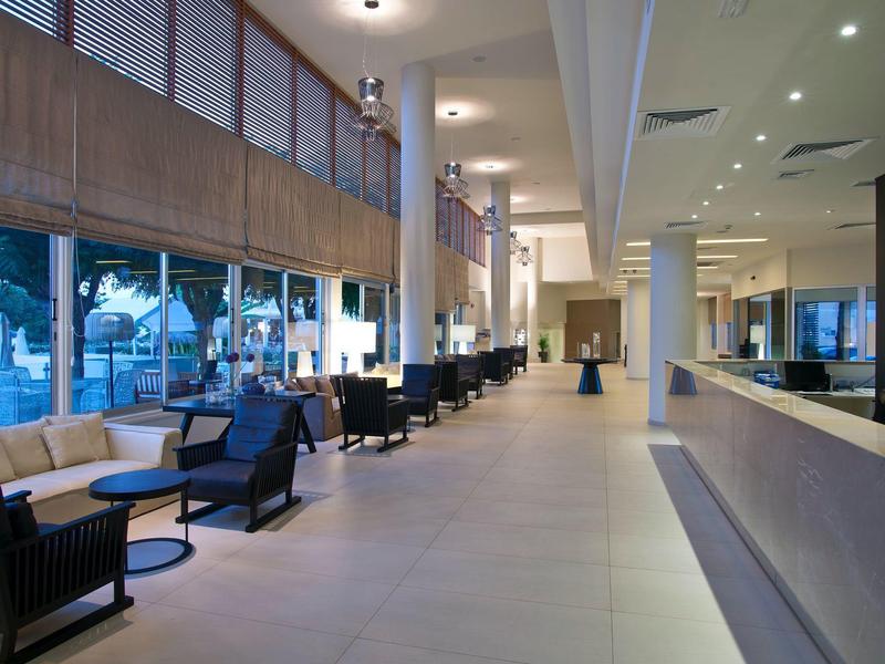 Moderne hotel lobby met zitgelegenheden en grote ramen met uitzicht naar buiten.