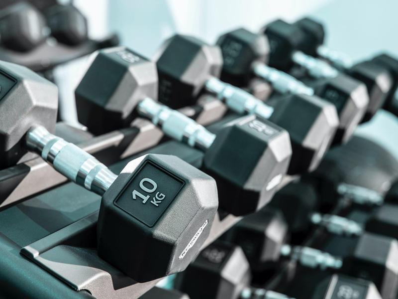 10 kg halters gerangschikt op een fitnessrek.