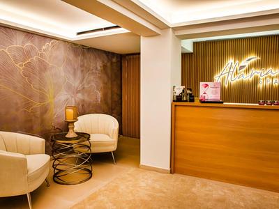 Accogliente area della hall dell'hotel con due poltrone e una reception moderna.