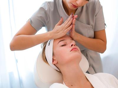 Una donna riceve un massaggio rilassante alla testa in una stanza spa luminosa.