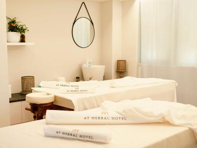 Sala benessere luminosa con due lettini da massaggio e illuminazione rilassante.