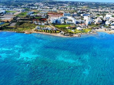 Località costiera con acqua blu chiara e hotel estesi lungo la riva.