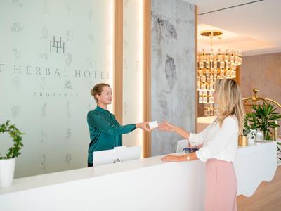 Receptionist consegna una tessera a una donna alla reception dell'hotel.