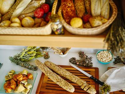 Pane e pasticceria con erbe e cereali disposti su un tavolo.