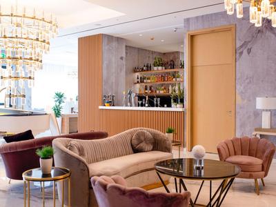 Lounge dell'hotel moderna con divani comodi, poltrone e tavoli eleganti.