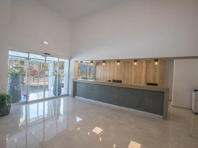 Moderner Hotel-Empfangsbereich mit elegantem Tresen und großer Fensterfront.