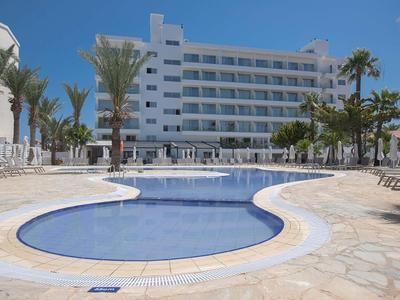 Moderner Hotelkomplex mit zwei verbundenen Swimmingpools und Palmen im sonnigen Außenbereich.