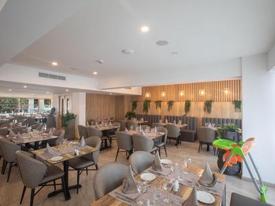 Modern eingerichteter Hotelrestaurant mit eleganten Tischen und Stühlen in neutralen Farbtönen.