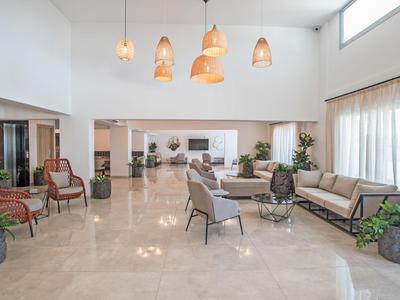 Heller Hotellobby mit bequemen Sitzgruppen, großen Fenstern und moderner Beleuchtung.