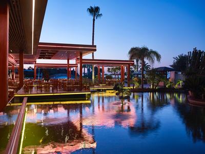 Restaurante moderno de hotel con terraza y piscina al atardecer