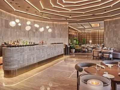 Moderner Hotel-Loungebereich mit stilvoller Bar, angenehmer Beleuchtung und bequemen Sitzgelegenheiten.