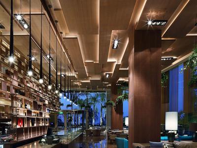 Área de salón moderna de hotel con iluminación elegante y asientos cómodos.