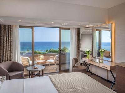 Helles Hotelzimmer mit Meerblick, Terrasse, modernem Mobiliar und gemütlicher Atmosphäre.